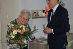 Od lewej: Jubilatka przyjmuję z rąk prezydenta Piotra Grzymowicza bukiet kwiatów