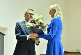 Od prawej: Iwona Godlewska, dyrektor szkoły odbiera z rąk Piotra Grzymowicza, prezydenta Olsztyna bukiet kwiatów.