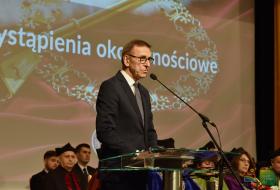 Na pierwszym planie przy mównicy stoi prezydent Olsztyna Piotr Grzymowicz, w tle członkowie senatu UWM