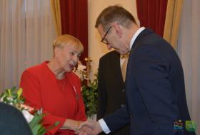Prezydent Olsztyna gratuluje jubilatce odznaczenia medalem za długoletnie pożycie małżeńskie.