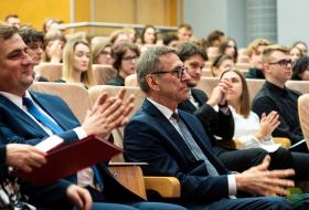 Goście inauguracji roku akademickiego UWM oklaskują na siedząco wystąpienia okolicznościowe. W pierwszym rzędzie Piotr Grzymowicz, prezydent Olsztyna