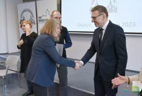 Prezydent Olsztyna gratuluje szefowej PCK Olsztyn, w tle dwoje uczestników