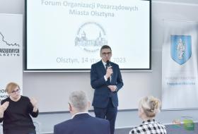 Prezydent Olsztyna na tle okolicznościowego slajdu