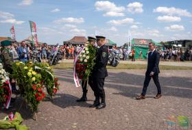 Zdjęcie przedstawia Pana prezydenta Piotra Grzymowicza i dwóch funkcjonariuszy Straży Miejskiej w Olsztynie idących złożyć kwiaty.