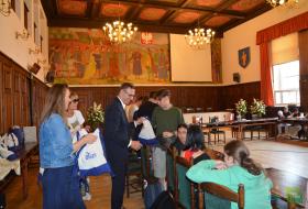 Zdjęcie przedstawia wręczanie upominków dla młodzieży przez prezydenta Piotra Grzymowicza.